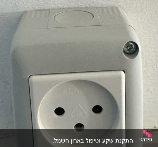 שקע חשמלי מותקן על קיר עם ברגים